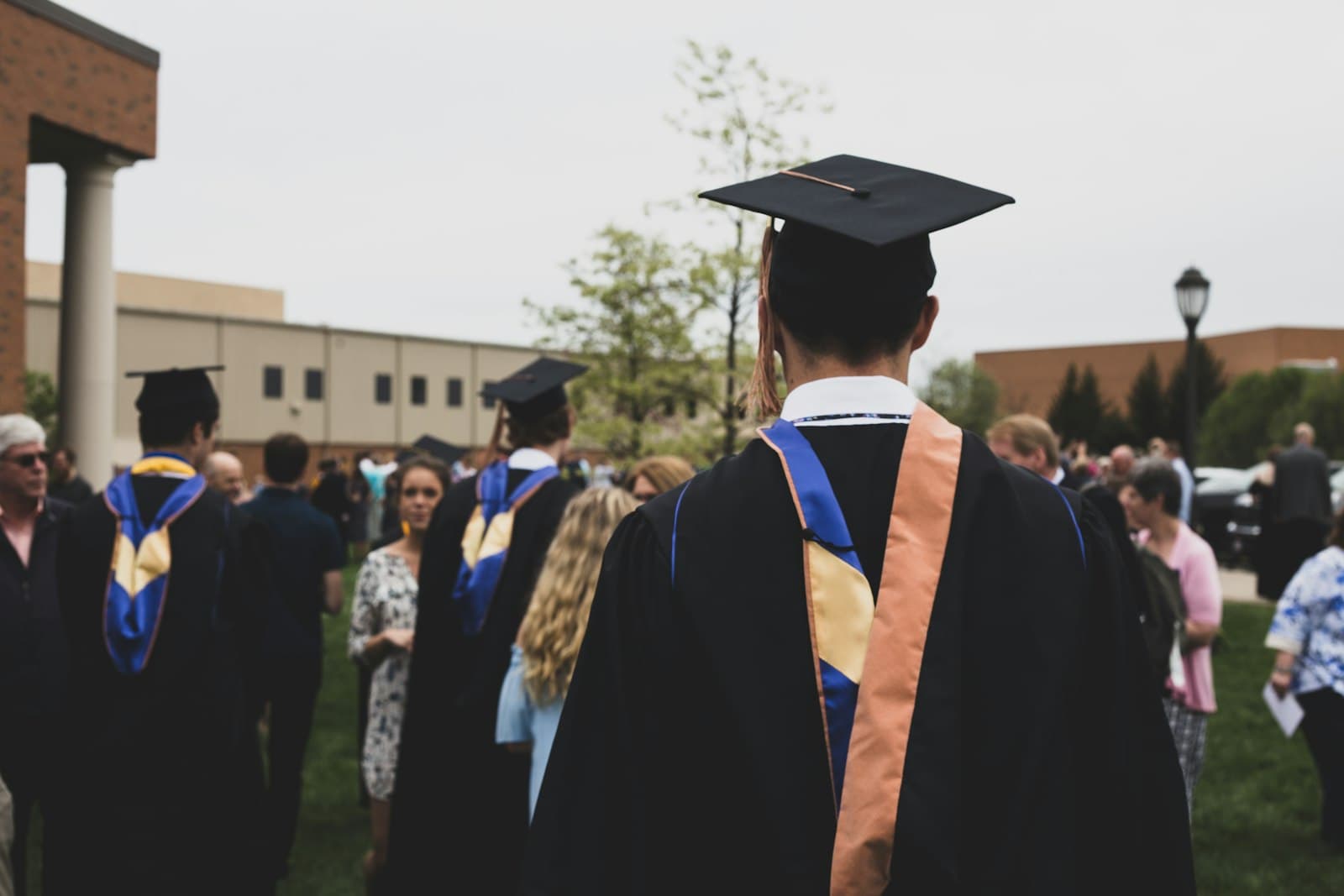 A graduate in cap and gown among classmates at a ceremony