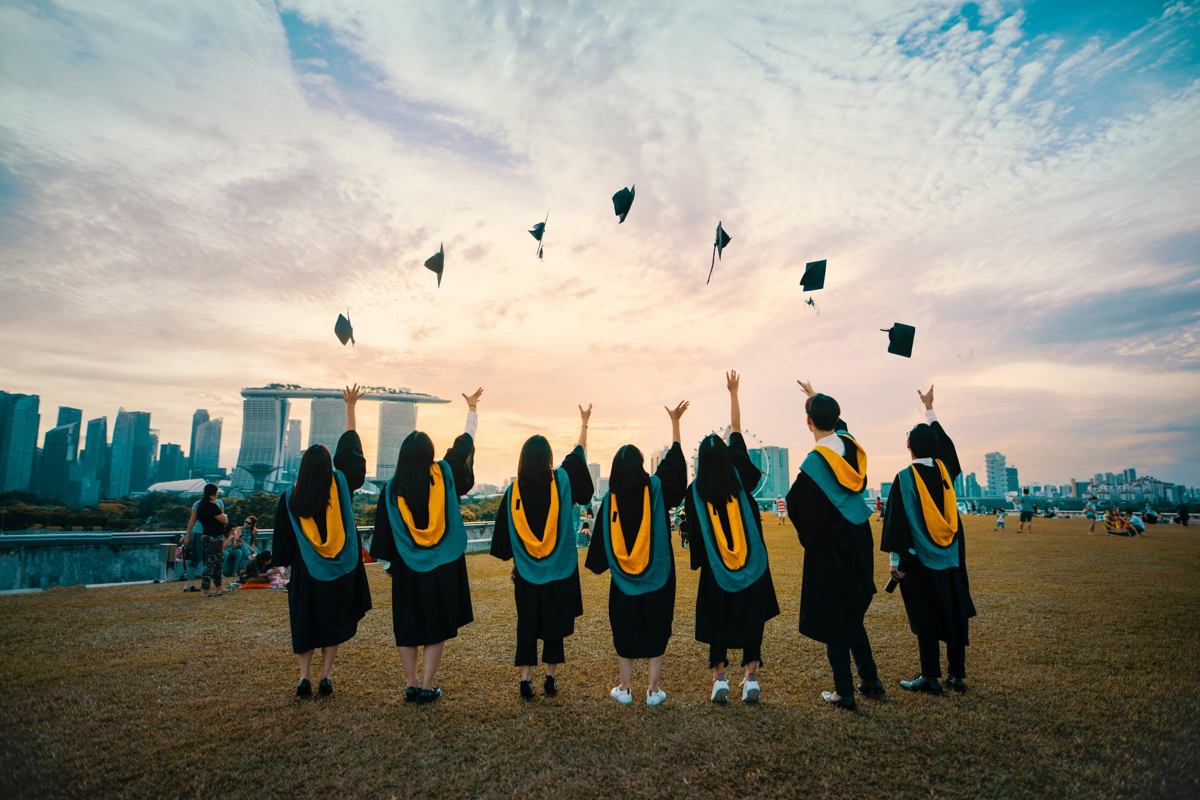 Graduates celebrating against a city skyline